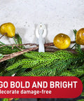 Damage Free Cord Bundlers For Walls No Tools Needed No Holes Holds Up To 2 Pounds Six Gray Bundlers With Twelve Strips Easy Cable Management For Hanging Electrical Cables securely holding decorative branches and fruits on a wall.