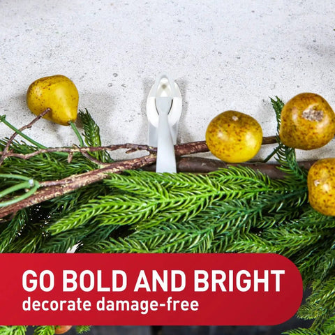 Damage Free Cord Bundlers For Walls No Tools Needed No Holes Holds Up To 2 Pounds Six Gray Bundlers With Twelve Strips Easy Cable Management For Hanging Electrical Cables securely holding decorative branches and fruits on a wall.