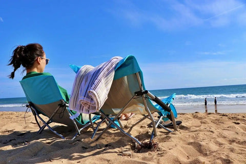 Person relaxing in Low Profile Beach Chair 2 Pack For Adults Folding And Portable With Cup Holder And Carry Bag at the beach