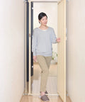 Woman using Tough As Nails Extra Tall Cat Gate Heavy Duty Steel Barrier with Foolproof Paw Lock in doorway.