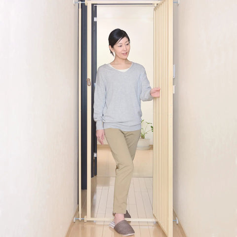 Woman using Tough As Nails Extra Tall Cat Gate Heavy Duty Steel Barrier with Foolproof Paw Lock in doorway.