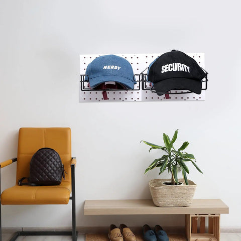 Eight Piece Wire Hat Display Racks For Slatwall Black Metal Baseball Hat Racks holding blue and black caps on wall pegboard.