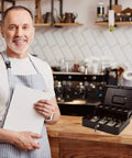 Smiling shop owner next to Lockable Cash Box With Money Tray For Cash Register Till, Metal Heavy Duty Safe Box on counter.