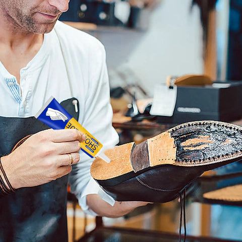 Man applying Dope Shoe Glue For Sole Repair Quick Dry Waterproof Adhesive Clear 60ml 45g to worn shoe sole in workshop.