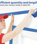 Person using Blue Painter Tape Bulk Pack 12 Rolls 2 Inch Wide 55 Yards Each For Wall Painting And Decorating DIY Friendly Safe Paper Masking Tape