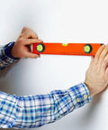 Person using 4pcs Acrylic Cylindrical Mini Spirit Level Tool for Precise Measuring against a wall for accurate leveling.