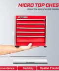 Person holding small red tool chest with five drawers labeled Micro Top Chest, shown with A5 notebook for scale comparison.