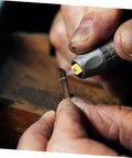 Close-up of a hand using a tool with a tungsten steel bit for jewelry crafting from the 30-Piece Cobalt PCB Drill Bit Set For Circuit Board Engraving And Jewelry Crafting With Micro Metric Tungsten Steel Bits For Drill Press And Precise Piercing On Small Electronics Projects.