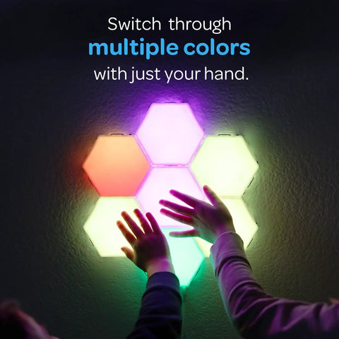 Hands touching 7 Piece Tap Tap Sensory Lights Kit With Touch And Remote Control Multicolor Magnetic Hexagon Tiles on wall.