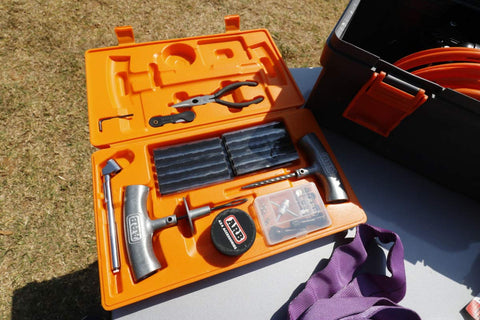 Open case of Speedy Seal 2 Universal Heavy Duty Tire Repair Kit with tools and 40 vulcanizing cords on grass surface