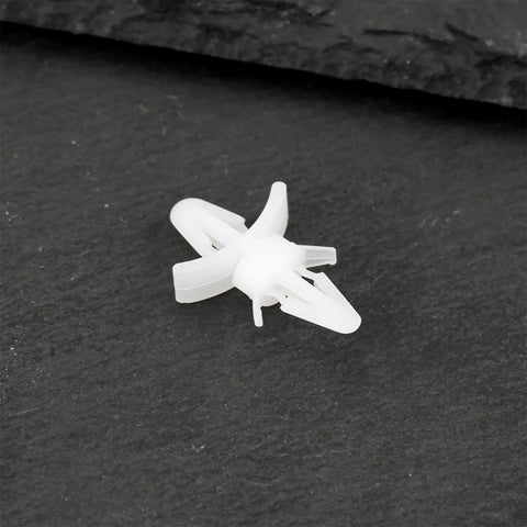 Top Shelf 100 Count White Pcb Standoff Mounting Clips Quick Snap Fit For 4Mm Holes on black surface, showing installation detail.