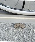 2 Pairs Bike Disc Brake Pads For Hydraulic And Mechanical Disc Brakes Replacement Pads next to bicycle tire on gravel
