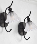 PUMING Black Wall Sconces Set of Two, Vintage Vanity Light Fixture with Flower Glass Shade mounted on wall.