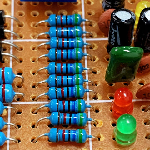 Blue metal-film axial resistors on a perforated prototyping board; several resistors visible