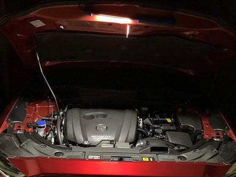 Rechargeable Portable COB LED And UV Work Light illuminating an open car engine bay with 1000 Lumens USB C Cordless Drop Light.