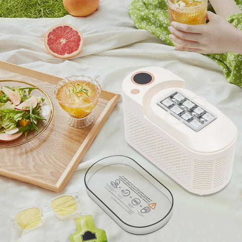 Great Slick And Totally Nifty Mini Countertop Ice Maker With 12V Car Adapter And Fast Freeze Cycle, white unit beside drinks and food.