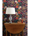 Custom Printed Colorful Blue Floral Vinyl Wallcovering Featuring Subtle Leather Texture on dark background with lamp and wooden table.