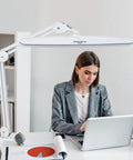 Task Lamp With Clamp For Desk Or Workbench 23 Inch Wide Head 117 LEDs 24W 2200 Lumen Dimmable Swing Arm Light used by woman