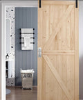 Wooden sliding barn door with stainless steel door pull handle installed in modern interior.