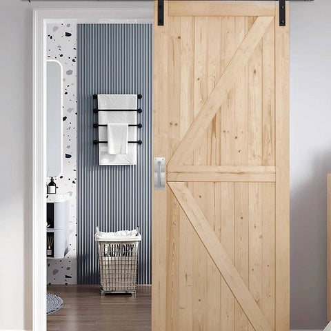 Wooden sliding barn door with stainless steel door pull handle installed in modern interior.