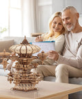 3D Wooden Puzzle Kit for Adults With SkyCity Cityscape, 600 Plus Pieces, Mind Blowing Mechanical DIY Craft That Doubles as a Music Box, Perfect STEM Toy Gift for Puzzle Fans and All Occasions. Wooden cityscape puzzle on table with couple assembling it