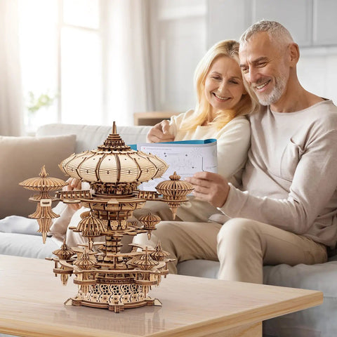 3D Wooden Puzzle Kit for Adults With SkyCity Cityscape, 600 Plus Pieces, Mind Blowing Mechanical DIY Craft That Doubles as a Music Box, Perfect STEM Toy Gift for Puzzle Fans and All Occasions. Wooden cityscape puzzle on table with couple assembling it