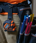 9235 Heavy Duty Magnetic Tape Measure with 16 Foot Reach clipped to tool belt next to colorful tools, showing double sided blade housing