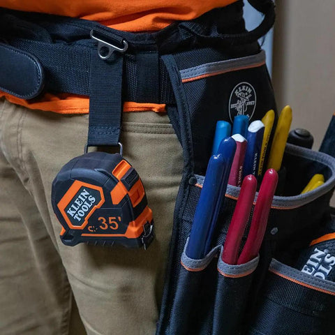 9235 Heavy Duty Magnetic Tape Measure with 16 Foot Reach clipped to tool belt next to colorful tools, showing double sided blade housing