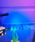Rechargeable Inspection Pen Light With 450 Lumen Flood And 140 Lumen Spot, 365 Nm UV Light illuminating a bathroom sink.