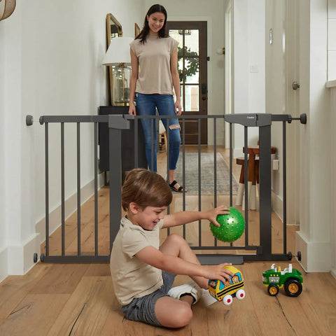 Auto Close Baby Gate For Stairs And Doorways With Easy Install Pressure Mounted Design Walk Through One Hand Operation Perfect For Pets And Little Ones In Black in hallway with child playing