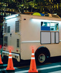 Night scene with 28 Inch Collapsible Traffic Cones Two Pack With LED Lights And Reflective Collar surrounding a parked truck