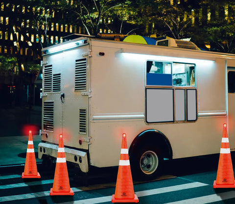 Night scene with 28 Inch Collapsible Traffic Cones Two Pack With LED Lights And Reflective Collar surrounding a parked truck