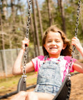 Child swinging outdoors on a porch swing hung with heavy duty black chain one third inch thick ten feet long perfect for outdoor use.