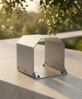 Heavy Duty Grey Foot Switch Guard Cover With Angled Hooded Shape And Textured Coating For Tight Machine Shop Spaces Durable Hardware Accessory on a stone surface.