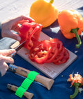 Nomad Camping Kitchen Utensil Kit With Serrated No 12 Folding Knife slicing red pepper on cutting board