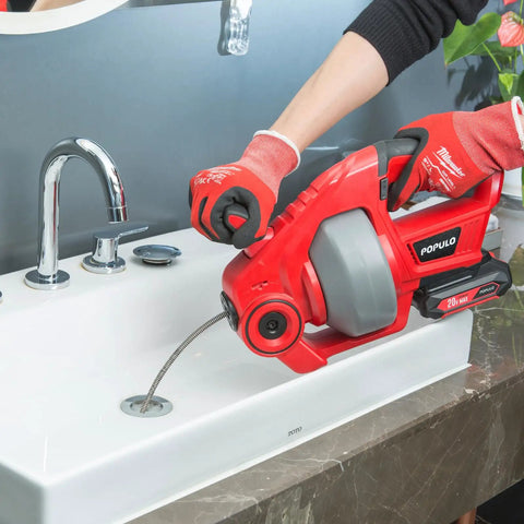 20V Cordless Drain Auger Auto Feed 25 Ft Drain Snake With Replaceable Cable being used in a bathroom sink to clear clogs.