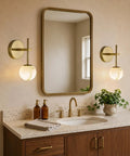 10 in Alabaster Wall Sconces Set of Two, Natural Marble Globe Wall Light, mounted beside a mirror in a bathroom.