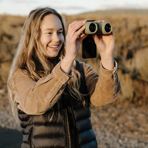 Person using Smartphone Photo Rig II Attachment For Binoculars And Telescopes, capturing photo outdoors, lightweight design