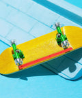 Close-up view of a miniature skateboard with orange ABS Rail Guards for Longboard and Electric Skateboard with Impact Resistant Construction