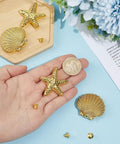 Slap These Killer Gold Cabinet Knobs Onto Your Dresser Or Vanity For An Instant Coastal Vibe Upgrade This Twelve Piece Hardware Set Features Detailed Starfish And Seashell Designs That Totally Revamp Your Space. A hand holding shiny gold starfish knob with a shell and fasteners on a tabletop.