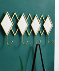 Dang Solid Wall Mount Coat Hook Featuring Heavy Duty Wrought Iron Craft With A Slick Rustic Copper And Gold Finish on green wall