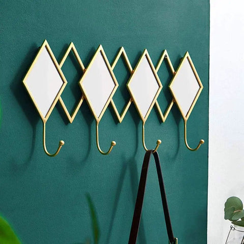 Dang Solid Wall Mount Coat Hook Featuring Heavy Duty Wrought Iron Craft With A Slick Rustic Copper And Gold Finish on green wall