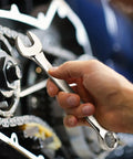 Person using a wrench on machinery, showcasing the 75-Piece Home Tools Kit With Plastic Toolbox Storage Case And Integrated Standing Tool Rack