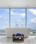 Spacious bathroom with ocean view featuring a freestanding tub and plant, with space for a Teak Shower Bench With Shelf And LiftAide Arms.