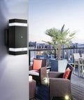 Dusk To Dawn Outdoor Wall Lights Two Pack With UV Sensor, Up And Down Front Porch Sconces illuminating a patio area.
