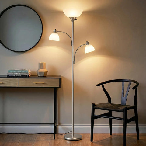 Double LED Floor Lamp With Two Reading Lights Dimmable Torchiere Tall Silver Standing Lamp for Living Room Office and Bedroom Reading Ultra Bright Three Bulb Warm White 3000K next to chair.