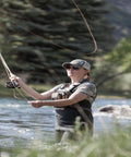 Angler wearing Ultra Lightweight Fly Fishing Vest With 14 Pockets And Front Zip Storage Olive Green Holds 4 Fly Tackle Boxes With Strap Pack