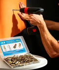 DIYer using All In One 180 Piece Self Drilling Drywall Anchors Kit With 90 Winged Anchors And 90 Screws For Gypsum Board Sheetrock And Hollow Walls No Pre Drill Required Fast Easy Mount In Seconds For Any Diyer on orange wall.