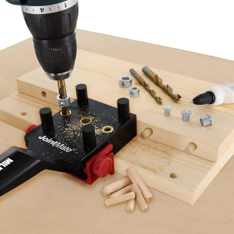 Self Centering Dowel Jig Kit For Woodworking in use with handheld jig, metal bushings, drill, dowels, and wood pieces for joints.