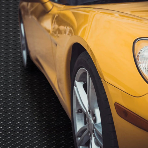 Yellow car parked on Heavy Duty Diamond Plate Rubber Flooring Roll 12 Inch By 20 Foot Non Slip Garage Mat For Workshop Outdoor Use.